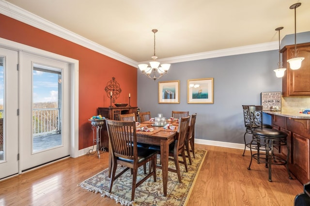 dining room featuring ornamental molding, light wood-type flooring, and baseboards