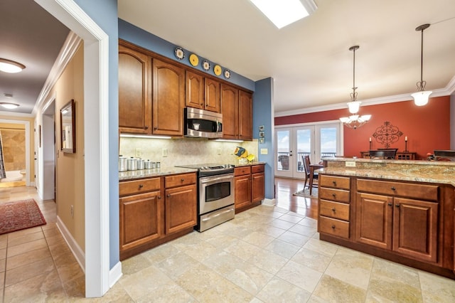 kitchen featuring brown cabinets, light stone counters, stainless steel appliances, and decorative light fixtures