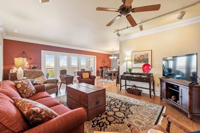 living area with ceiling fan with notable chandelier, wood finished floors, french doors, ornamental molding, and track lighting