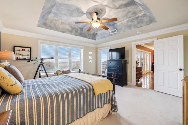 bedroom with ornamental molding, a tray ceiling, visible vents, and carpet