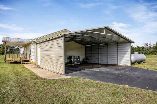 view of outbuilding with aphalt driveway and a carport