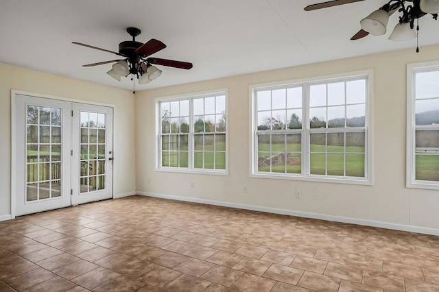 unfurnished sunroom featuring a ceiling fan