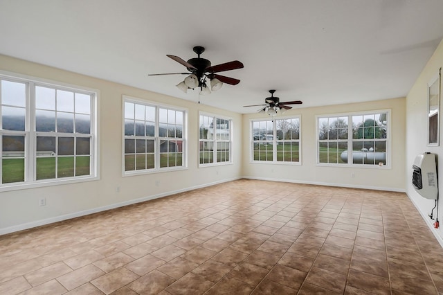 unfurnished sunroom featuring heating unit and ceiling fan