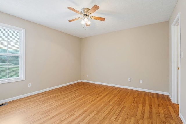 empty room featuring a ceiling fan, light wood-style flooring, and baseboards