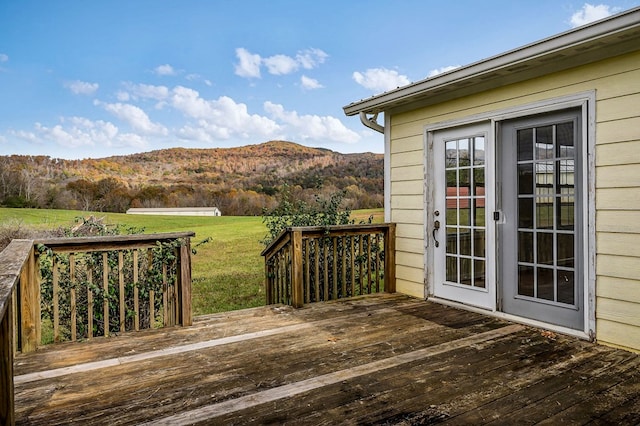 wooden deck with a mountain view and a yard