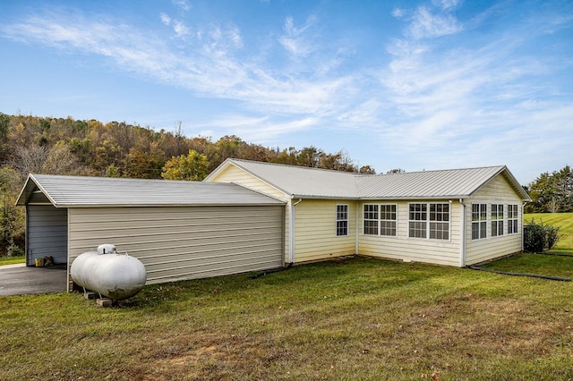 rear view of house with metal roof and a lawn