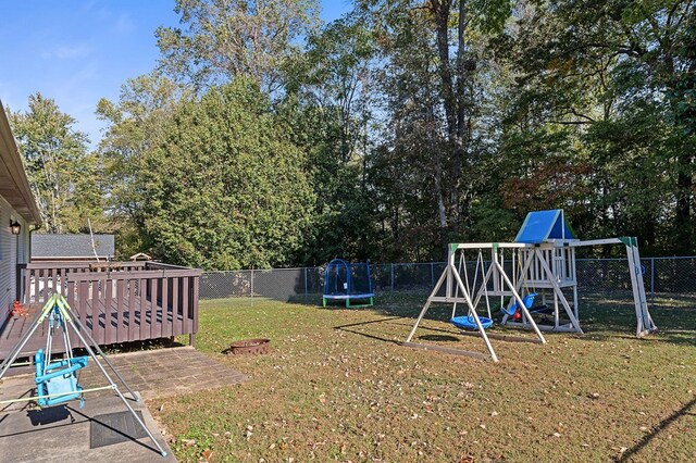 view of yard with playground community, a trampoline, and a fenced backyard