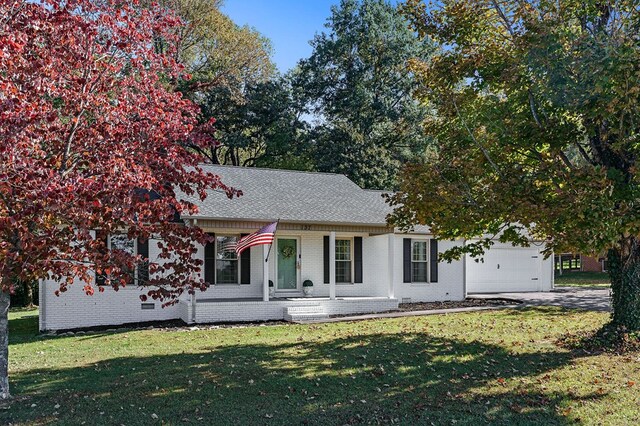 view of front of house featuring a porch, a front lawn, and brick siding