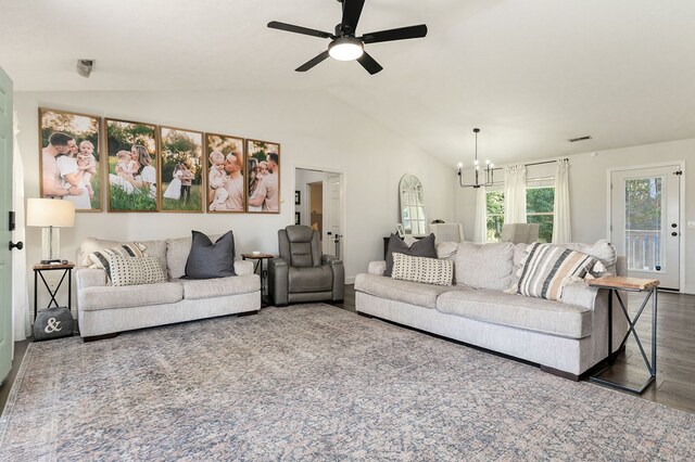 living area with lofted ceiling, visible vents, dark wood-type flooring, and ceiling fan with notable chandelier