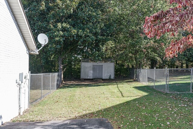 view of yard with a storage unit, an outdoor structure, a fenced backyard, and a gate