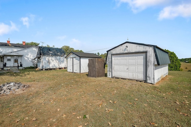 detached garage featuring driveway and a storage unit