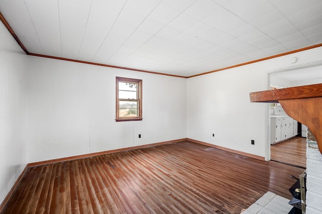 unfurnished living room featuring ornamental molding, wood finished floors, and baseboards