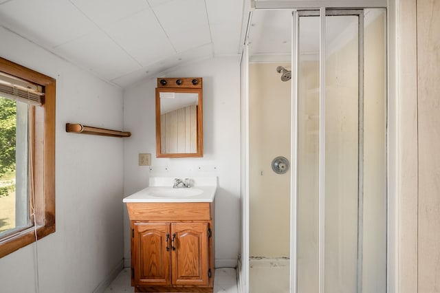 bathroom with vaulted ceiling, a stall shower, and vanity