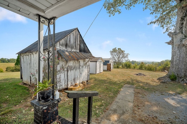 view of yard with an outbuilding, a storage unit, and a rural view