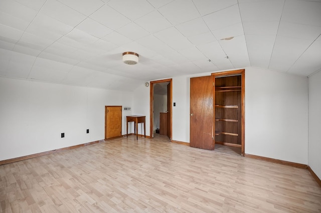 bonus room with baseboards, vaulted ceiling, and light wood-style floors