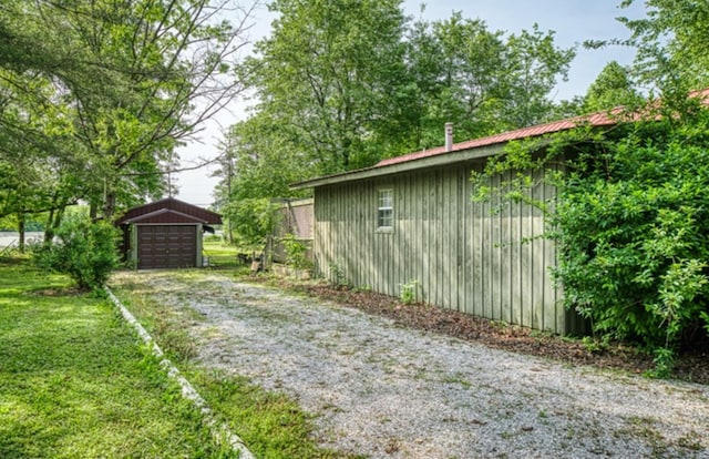 exterior space with a garage, an outbuilding, and driveway