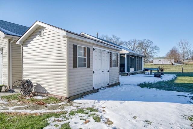 view of snowy exterior featuring a sunroom