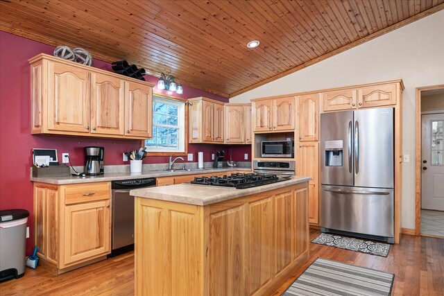 kitchen with lofted ceiling, a kitchen island, stainless steel appliances, light countertops, and light wood-style floors