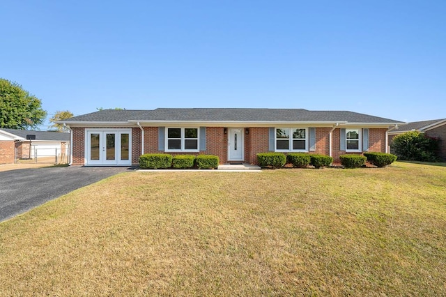 ranch-style home featuring a front yard, french doors, and brick siding