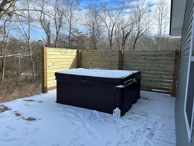 yard covered in snow with a hot tub and fence