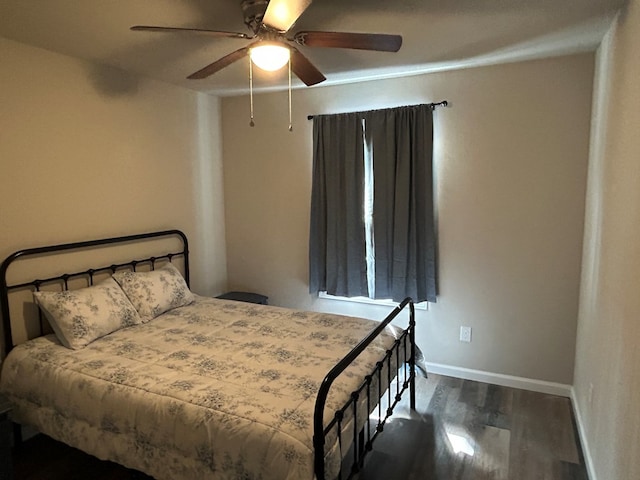 bedroom featuring a ceiling fan, baseboards, and dark wood-type flooring