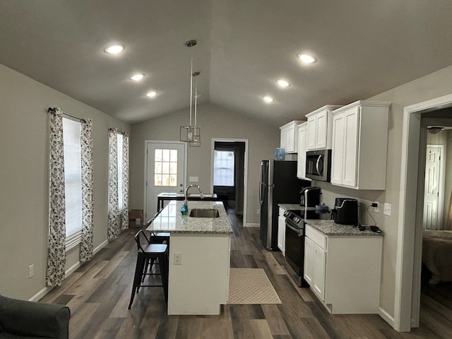 kitchen with a kitchen island with sink, a sink, white cabinetry, appliances with stainless steel finishes, and pendant lighting