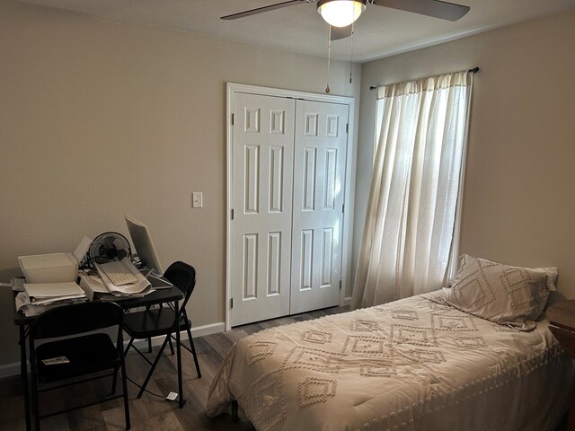 bedroom featuring dark wood-style floors, a ceiling fan, baseboards, and a closet