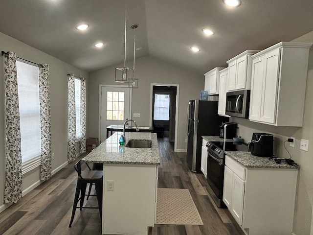 kitchen featuring a sink, white cabinetry, electric stove, stainless steel microwave, and an island with sink