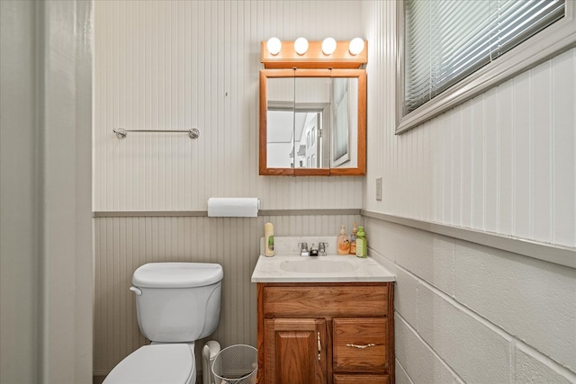 bathroom featuring toilet, wainscoting, and vanity