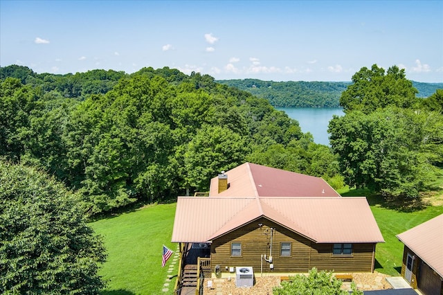 birds eye view of property featuring a forest view and a water view