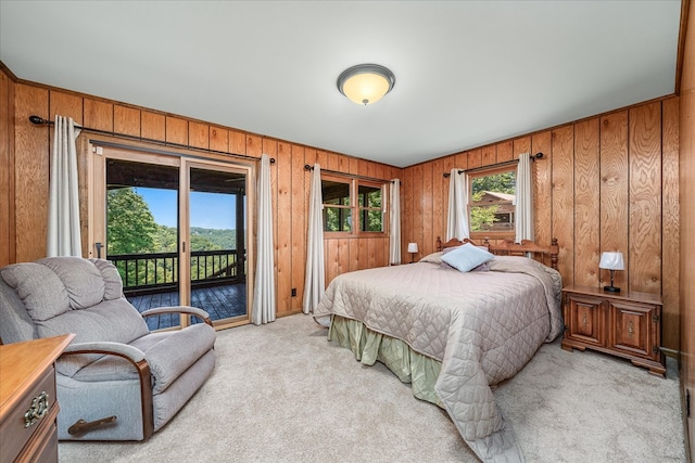 bedroom with light carpet, wooden walls, and access to exterior