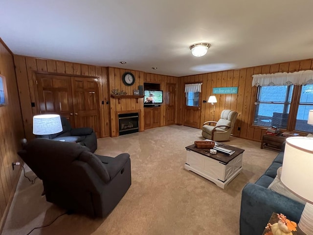 living area with light carpet, a fireplace, and wooden walls