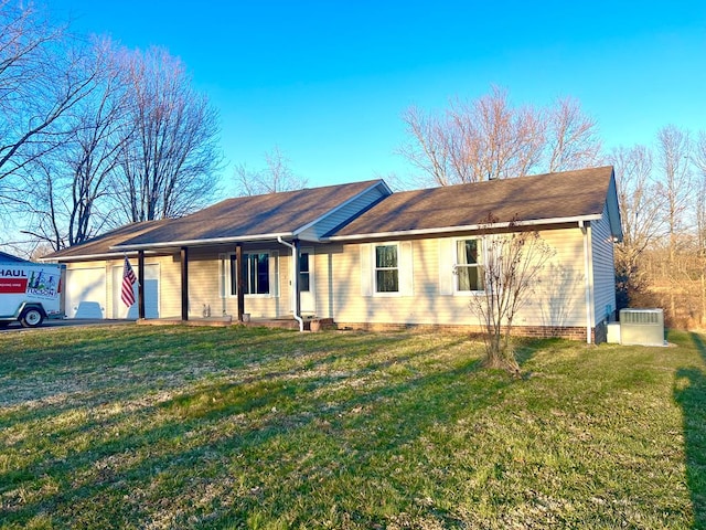 single story home featuring a garage, a front lawn, cooling unit, and aphalt driveway