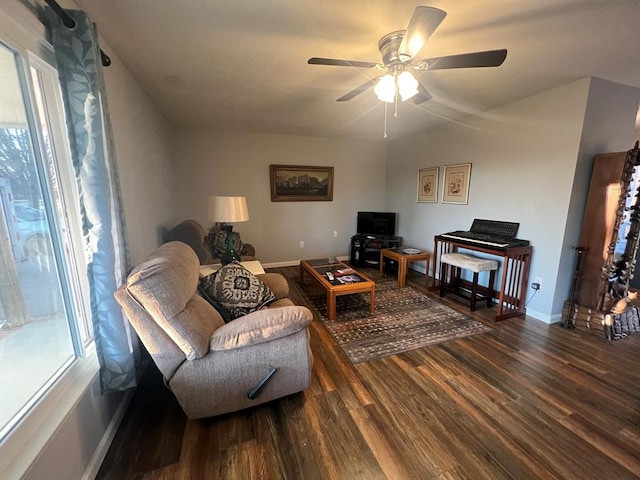 living room with a ceiling fan, baseboards, and wood finished floors