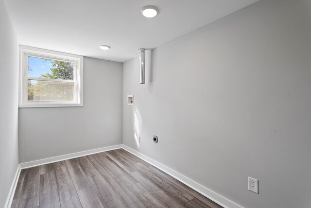 spare room featuring baseboards and wood finished floors