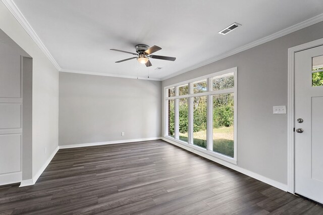 spare room with baseboards, ornamental molding, dark wood finished floors, and a wealth of natural light