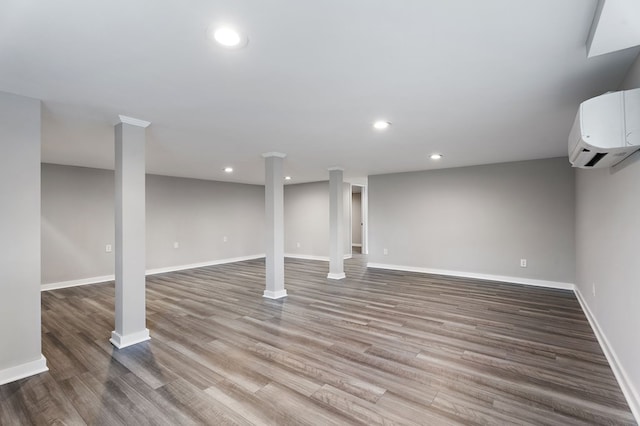 finished below grade area with baseboards, a wall mounted AC, wood finished floors, and recessed lighting