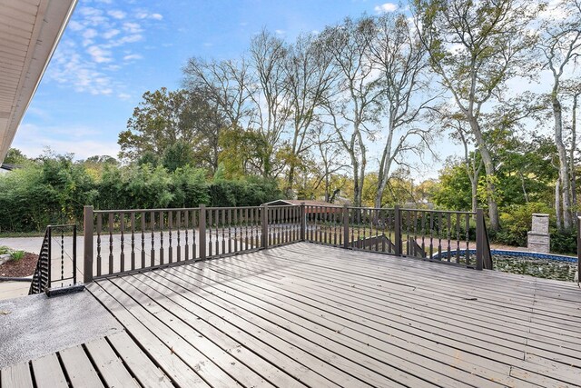 wooden deck featuring an outdoor stone fireplace