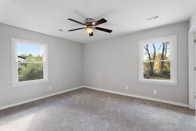 spare room with baseboards, visible vents, and a healthy amount of sunlight