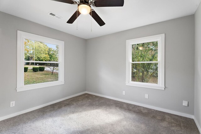 carpeted empty room with visible vents, ceiling fan, and baseboards