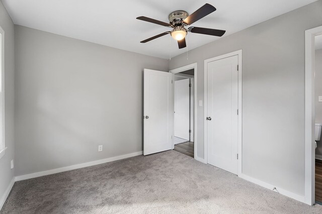 unfurnished bedroom with baseboards, a ceiling fan, and light colored carpet