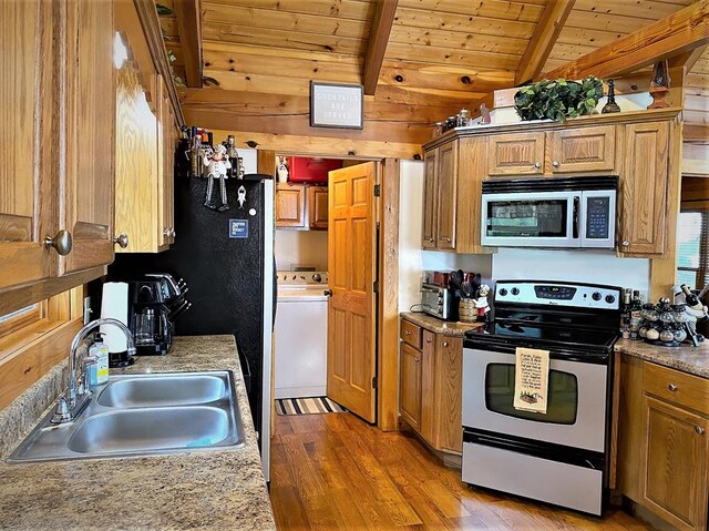 kitchen featuring vaulted ceiling with beams, a sink, stainless steel range with electric stovetop, wood ceiling, and light wood-type flooring