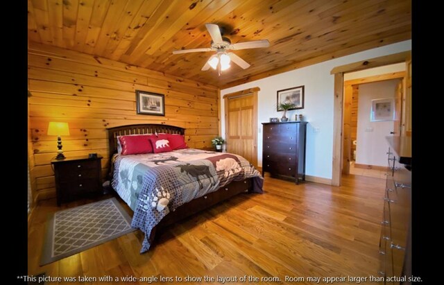 bedroom featuring wooden ceiling, wood finished floors, baseboards, and wood walls