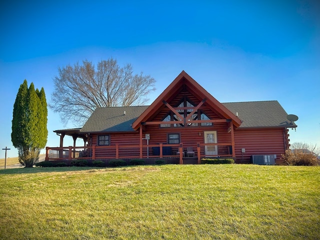 back of property with log siding, a yard, and roof with shingles