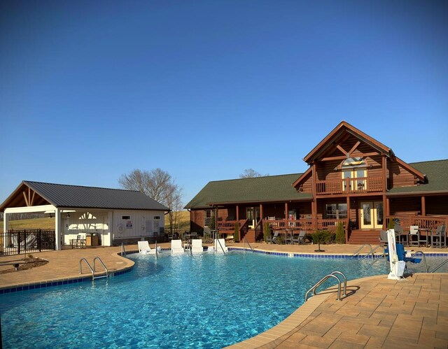 community pool featuring a patio and fence