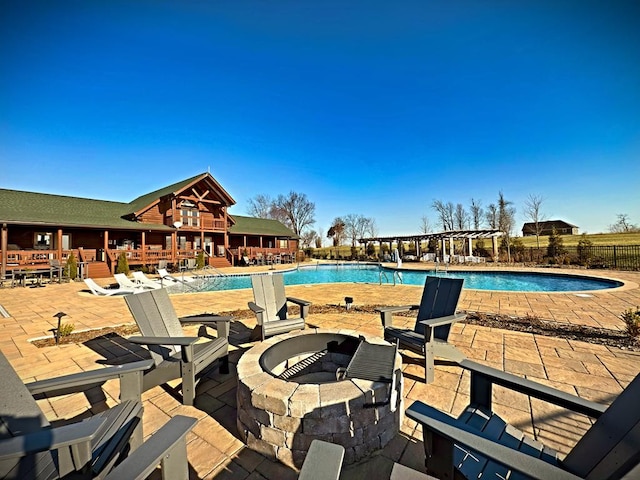 pool featuring a patio area, a fire pit, and fence