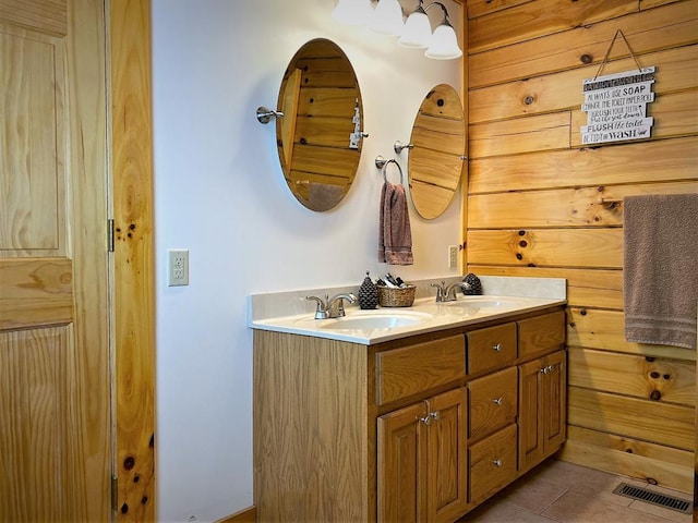 bathroom with tile patterned flooring, double vanity, visible vents, and a sink