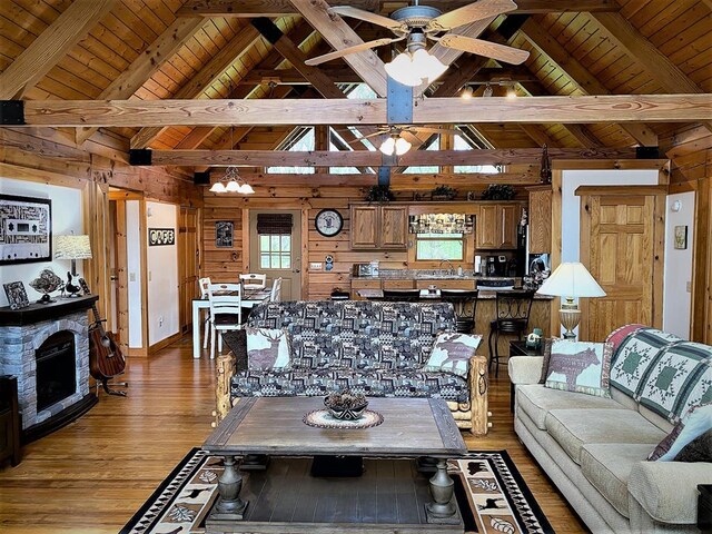 living area with wooden walls, light wood-style flooring, wood ceiling, and ceiling fan