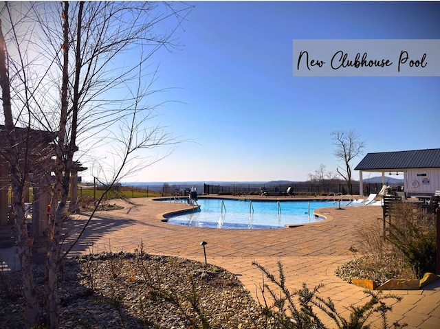 community pool featuring a patio and fence