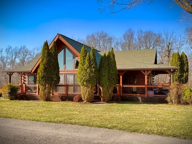 exterior space featuring covered porch, log exterior, a front lawn, and roof with shingles